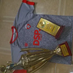 The spoils of victory. This photo displays a winner's trophy and a "Best Coach" award alongside our iconic DSP jersey. We win as a team, and we are recognized for our excellent coaching.