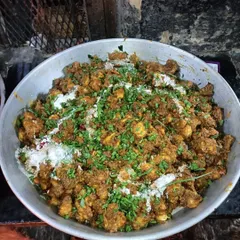 A large bowl of a dry chicken starter, garnished with fresh herbs. This dish is full of flavour and has a great texture, perfect for kicking off a meal.