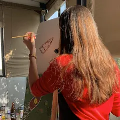 Here’s a behind-the-scenes look at one of our painters getting into the zone. With the sun streaming in and a drink by her side, it’s the perfect setup for a relaxing, creative evening.