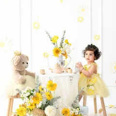 A whimsical teddy bear tea party for a sweet toddler. The vibrant yellow floral theme creates a cheerful, sunny atmosphere, perfect for capturing her innocent joy and imagination.