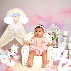 A magical unicorn-themed half-birthday session. The setup includes a rainbow, a teepee, and unicorn props to create a whimsical world for your little one.