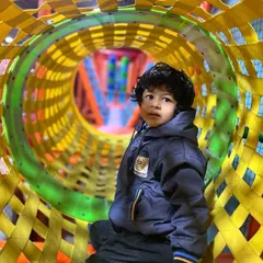 This student is exploring one of our colorful play tunnels, a key feature of our multi-level soft play area. These structures encourage physical activity and imaginative exploration during school outings.