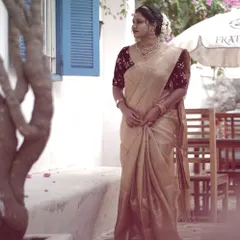 A full view of this bride's timeless engagement style. The simple, elegant saree is complemented by understated makeup that focuses on flawless skin and a sophisticated hair bun.