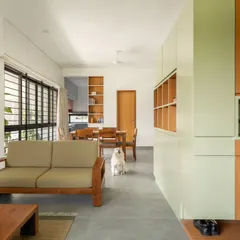 An open-plan living and dining area in the DUBEY Home. This view highlights the fluid layout, the use of warm wood tones against a neutral palette, and our consideration for all family members, including pets, in the spatial design.