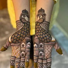 A bold and beautiful design featuring crowned peacocks. The symmetry and detail in the feathers and the surrounding geometric patterns make this a striking choice for a bride.