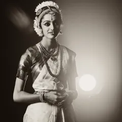 An elegant, softly lit portrait of a Bharatanatyam dancer. The sepia tone adds a timeless, classic feel to this artistic performance shot.