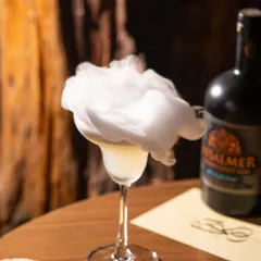 Creating drama with a smoky gin cocktail. This kind of shot is perfect for a bar's social media, creating intrigue and highlighting the craft behind the drink.