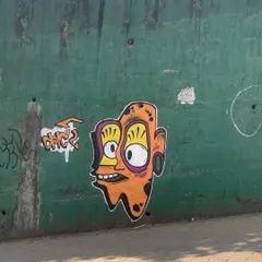 A quick character I painted on a green wall. This trippy, wide-eyed face is a recurring theme in my work, exploring a more psychedelic and abstract style.