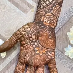 A close-up of a full-coverage bridal design after the henna paste has dried. Notice the rich texture and the mix of bold florals with fine, delicate filler patterns like netting and leaves.