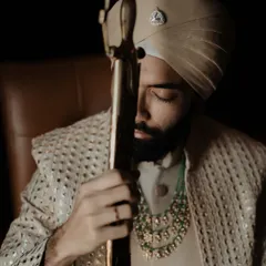 A powerful and regal portrait of the groom with his kirpan. We use dramatic lighting to highlight the traditional elements and the groom's commanding presence.