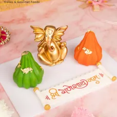 This Modak Hamper is filled with devotion and sweetness. It includes a Ganesh idol, a 'Shree Ganeshay Namah' message made of chocolate, and two festive modaks, making it a complete and thoughtful gift.