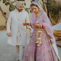 A candid moment of a Sikh couple walking together after their Anand Karaj, the bride adjusting her beautiful kalire.