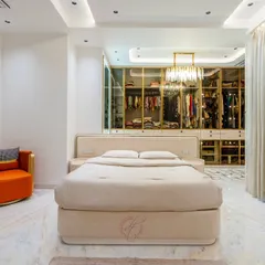 We believe a bedroom should be a sanctuary. This master suite features an open-concept design, seamlessly integrating a stunning walk-in closet with glass and gold-trim doors, creating a space that is both aspirational and deeply personal.