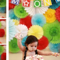 A fantastic action shot of the baby with cake-covered hands, set against a colorful backdrop. This is what a fun cake smash is all about.