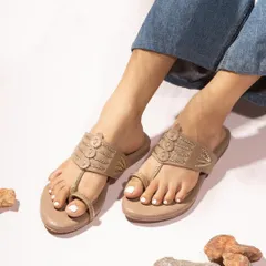 An on-model shot of casual beige toe-ring sandals, styled with denim. This shows the footwear in a relatable, everyday context, highlighting comfort and style.