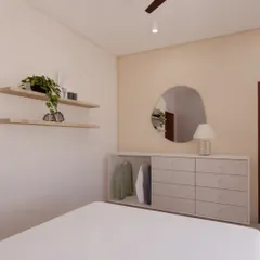 A detail from a Japandi bedroom, showing a minimalist chest of drawers with an open section for frequently used items. The design uses light wood tones and an organic-shaped mirror to maintain a sense of calm and order.