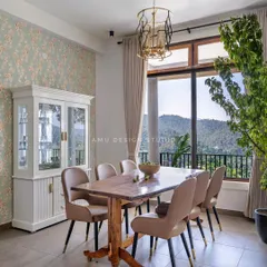 The dining area offers an unparalleled view, with a solid wood table and a white crockery unit, making every meal a special occasion.