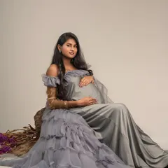 Seated gracefully, this mother-to-be is a vision in a layered grey gown. I use posing and styling to highlight both the beauty of the dress and the serene joy of pregnancy.