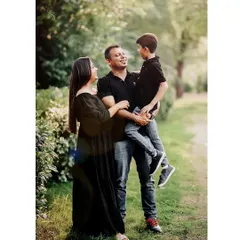 A full-length portrait of a family of three enjoying a walk in the park. Outdoor sessions like this allow for natural interactions and result in authentic, lifestyle family photos.