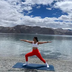 Holding a strong Warrior II pose by Pangong Lake. This foundational yoga asana is incredible for building leg strength and focus, proving that true power comes from finding stillness and stability even in the most challenging conditions.