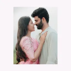 An intimate close-up, nose-to-nose. The soft, muted color palette enhances the romantic and gentle mood of the portrait.