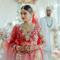 My bride Mansi, ready to walk down the aisle. Her complete look, from the intricate red lehenga to the stunning jewelry and my signature glowing makeup, creates a vision of timeless bridal elegance.