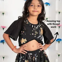 It's all in the details. This black lehenga choli features beautiful thread work with a whimsical cat and floral design, plus a touch of mirror work on the neckline for extra sparkle.