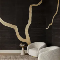 The 'Adorn' wallcovering by Phillip Jeffries, inspired by Kintsugi. The large-scale metallic branch design on a dark, textured background channels strength and uniqueness, creating a space that resonates with timeless beauty.