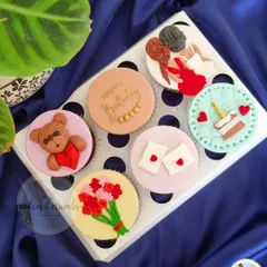 A beautiful set of custom cupcakes for a best friend's birthday. Each topper tells a little story, with designs like a teddy bear, a bouquet of flowers, and two best friends.