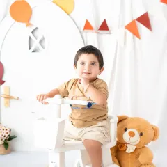 A simple and classic toddler portrait. This little boy's sweet expression is the focus, with a clean, white backdrop and a few simple props.