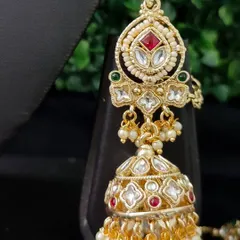 A classic kundan jhumka with red and green stones and pearl drops. This versatile rental earring can be paired with many different necklaces.
