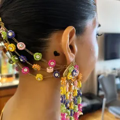 A detailed close-up of the colorful accessories woven into Aish's Haldi braid. These beautiful handcrafted pieces add a unique and personal touch to the traditional hairstyle.