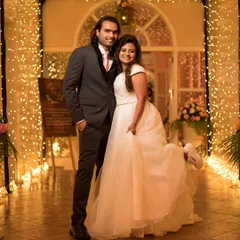 A fun and quirky portrait of a couple after their Christian wedding, with the bride playfully showing off her sneakers under her white gown.