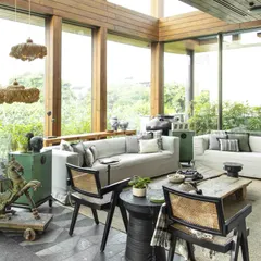 The conservatory features granite flooring with a unique pattern, chairs by Mahendra Doshi, and light installations by Oorjaa. The entire space is a curated collection of handcrafted pieces that exude a peaceful, timeless charm.
