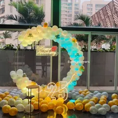 For a grand 25th anniversary celebration, I created this elegant circular balloon arch in a corporate lobby. The design combines white and gold balloons with dynamic lighting, a "Happy Anniversary" neon sign, and large marquee numbers to create a stunning photo opportunity.