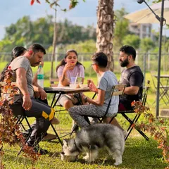 A family and their Husky puppy enjoying snacks and drinks at our outdoor cafe seating.