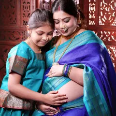 Celebrating the journey to motherhood with our traditional Maharashtrian maternity shoot. Here, a mother-to-be and her daughter share a quiet moment, beautifully dressed in matching Paithani-style sarees.