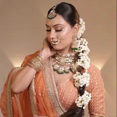 The complete bridal look, featuring a floral braid adorned with fresh mogra flowers. This hairstyle is a timeless choice for brides who want a traditional yet elegant look.