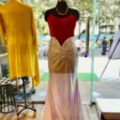 A show-stopping off-shoulder gown designed for the red carpet. The vibrant red velvet top contrasts beautifully with the iridescent, shimmering skirt, creating a silhouette that is both bold and elegant.