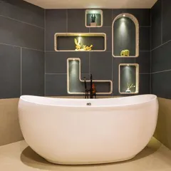 A dreamy, bubble-inspired bathroom designed for a young client. The freestanding tub is set against a dark tiled wall with custom-lit, bubble-shaped niches for a playful yet sophisticated look.