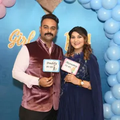 The happy couple holds up "Daddy to be" and "Mommy to be" signs, a fun and popular shot for baby showers.