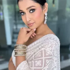 Another angle of this stunning look, showcasing the clean lines and flawless complexion. The sleek bun and statement earrings complete this elegant party style.
