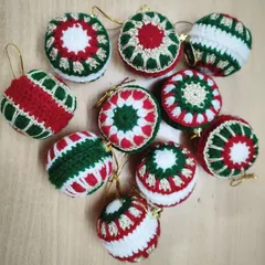 A collection of our handmade crochet Christmas baubles. We create them in traditional red, green, and white with various patterns, perfect for giving your tree a classic, crafty look.