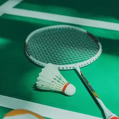 Ready for action. A racket and shuttlecock waiting on the clean lines of our court.