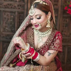 This complete bridal look features a red lehenga, traditional red choora, and a stunning Kundan jewellery set with a nath and maang tikka, all available for your shoot.