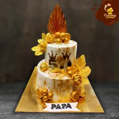A grand celebration for a grand man. This two-tier golden jubilee cake was designed for a 50th birthday, featuring elegant gold accents, crowns, and a "Papa" banner to honor the special milestone.
