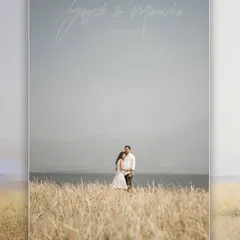 A beautiful landscape portrait with the couple standing in a field of tall grass by the water, perfect for a save-the-date.