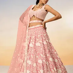 A studio shot of a beautiful pastel pink lehenga with white floral embroidery. This is a perfect, dreamy outfit for a daytime wedding or engagement.