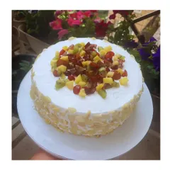 My fresh fruit cake is a celebration of summer. Topped with a colorful medley of seasonal fruits like kiwi, grapes, and pineapple, and coated with crunchy almonds, it's as beautiful as it is delicious.