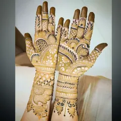This design features a prominent peacock on one palm and a lotus on the other, both surrounded by dense, traditional patterns that extend up the arm.